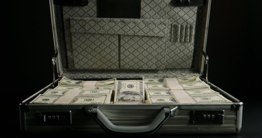 Packs of cash falling into a metal case filled with money. 100 dollar bills in a briefcase. Finance, investing, business concept close up 4k footage Royalty-Free Stock Footage #1078597523