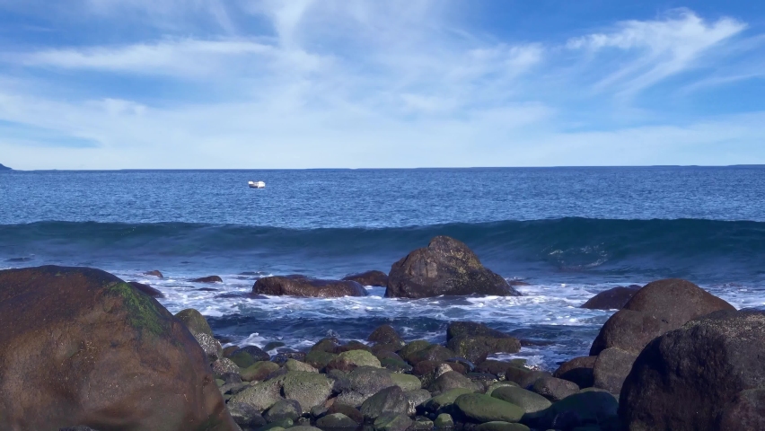 Amazing colorful waves of sea are washing big stones on a breakwater in sunny day. Hawaii, United States