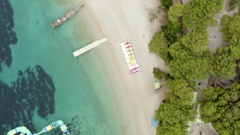 Inflatable Slides And Obstacles Of Aquapark Zlatni Rat Floating On Clear Water In Bol, Brac Island, Croatia. - aerial