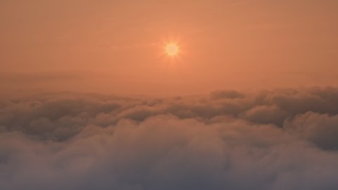 Shot for end titles: Dramatic landscape of sunrise due to thick clouds. Pink sun above clouds during foggy dawn. Magical dawn - cinematic flight over fluffy clouds. Drone aerial shot. วิดีโอสต็อก
