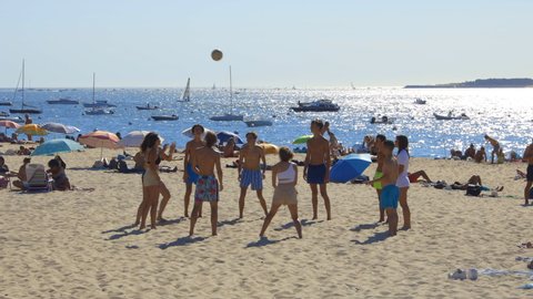 Arcachon, France - August 2021 : Group of teenager friends playing volley-ball on the Moulleau beach on the Arcachon Bay on a summer day
