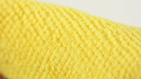 macro view of yellow microfiber dusting cloth, close-up on texture of water absorbing synthetic fabric