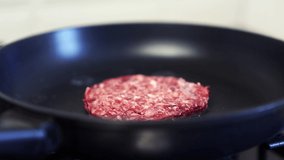 Minced beef meat frying on hot pan in kitchen. Video clip of ground beef cutlet for hamburger being fried in close up