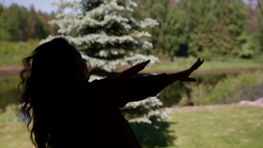 silhouette of an elegant woman dancing an oriental dance in nature