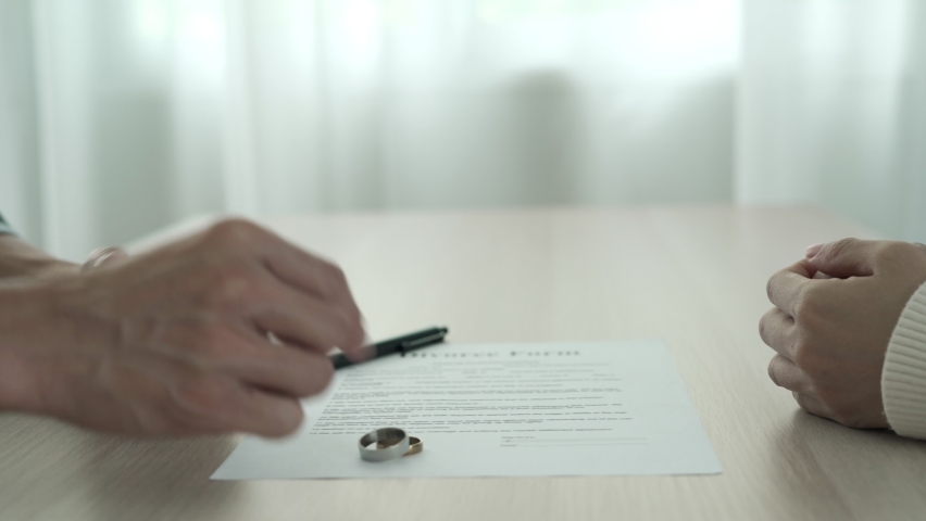 Love problem and divorce. Husband and wife remove married ring between waiting sign divorce document. Husband and wife quarrel problem family. | Shutterstock HD Video #1078623638