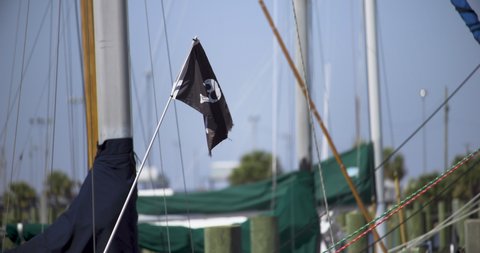 Black sailing flag with Skull and Crossbones flying in the wind