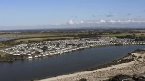 Pagham Lagoon situated next to the harbour and the seafront with Holiday homes on the bank at this holiday destination in Southern England. Aerial footage.