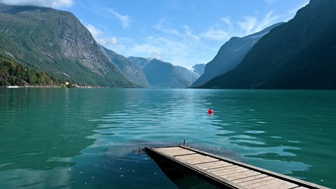Beautiful Lake Lovatnet in Norway with a jetty crossing the turquoise water.