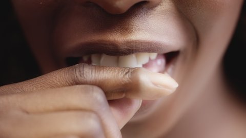 Black woman putting chewing gum in mouth, fresh flavor, healthy teeth, macro