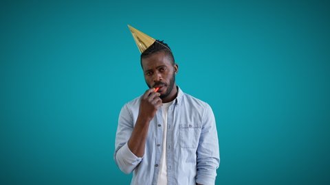 Sarcastic guy blowing party horn on blue background, ruined holiday, failure