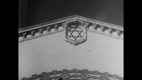 1940s: Star of David on top of synagogue. Plaque commemorating Touro Synagogue as oldest in U.S.. Outside synagogue. Service inside synagogue. Soldiers march in parade. Man speaks on park bench.