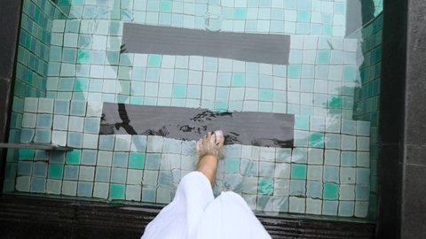 First-person View to Woman Legs Walking into Swimming Pool with Blue Water on Modern Villa. Travel Lady in Hotel Bathrobe on Holidays in Tropical Hotel. Vacation in Thailand