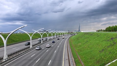 Vehicle traffic on the expressway. Modern highway, green lawn on the roadside