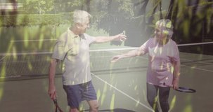 Composite of happy caucasian senior couple embracing after tennis, with grass and nature. healthy retirement, fitness and wellbeing concept digitally generated video.