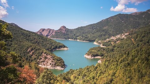 Time lapse of small boats on Lac de Tolla and the mountains and forests of Corsica