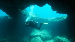 Scuba diver photographer swims in the cave, 4K - 60 fps. Cave diving in Mediterranean Sea, Cyprus