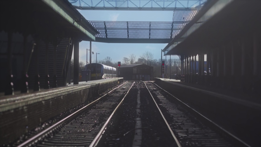 Railway Tracks Train Station Departure Slow Motion. POV scene train leaving station in slow motion. Railroad tracks travel shot