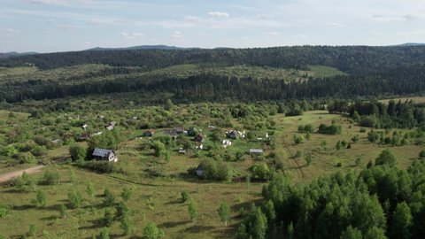 Aerial Landscape: summer mountain village with forests, fields, human settlement in Bashkortostan. Majestic landscape.