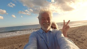 Portrait of couple of mature and old people enjoying summer at the beach looking to the camera taking a selfie together with the sunset at the background. Two active seniors traveling outdoors.
 - Powered by Shutterstock - Get 15% off with code: PIKWIZARD15