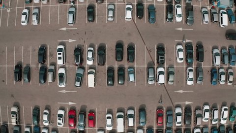 Shopping mall parking lot with many cars, aerial top view from drone