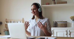 Young businesswoman in headphones solve business remotely use laptop and videoconference, lead distant negotiations working from homeoffice. Modern tech, video call event, job interview e-hire concept