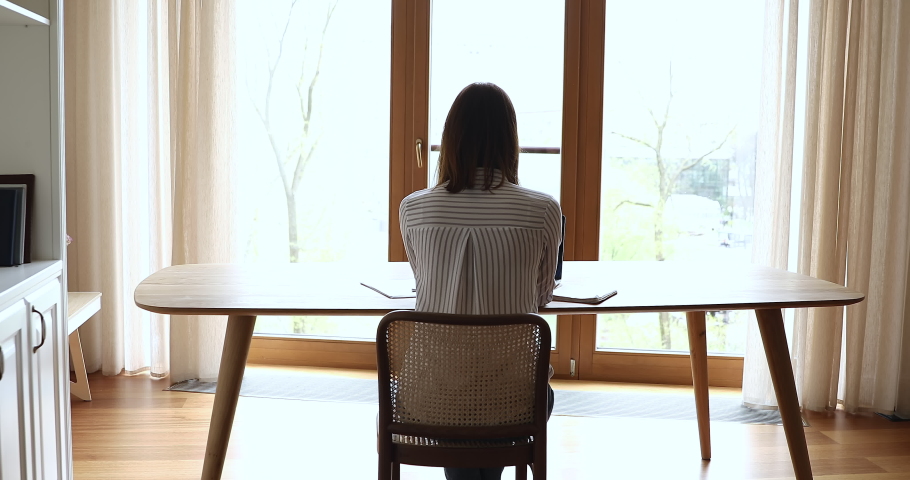 Rear back view young businesswoman sit at workplace homeoffice desk accomplish work lean on chair feels satisfied by work done, stretch arms reduce fatigue, put hands behind hands. Take break concept Royalty-Free Stock Footage #1078695227