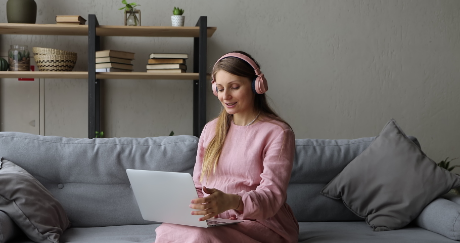 Pregnant woman in headphones sit on couch makes videocall, receive consultation from gynaecologist via videoconference. Online medical counsel at quarantine. Virtual remote meeting with family concept Royalty-Free Stock Footage #1078695239