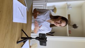 Professional occupation woman sit at table at homeoffice make speech in front of smartphone, provide counseling remotely, help to client, vertical view. Vlogging, modern tech, video call event concept