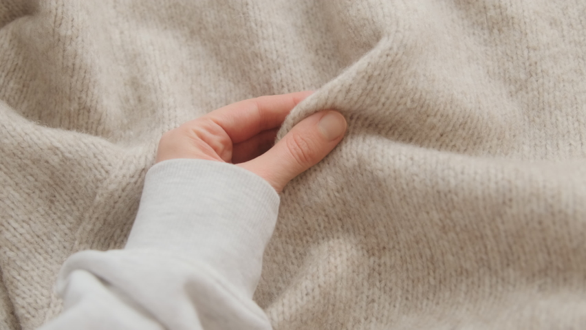 Hand touching knitted wool cloth or warm fluffy sweater. Handcraft knitting woolen fabric surface.  Royalty-Free Stock Footage #1078699433