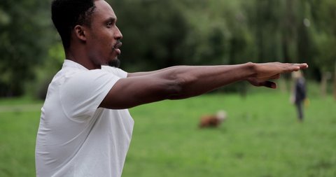 African american man limbering-up and stretching legs after running jog workout. Runner stretching and warming-up before running. Athlete  exercising in sportswear.