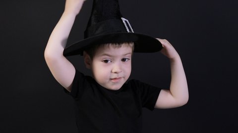 A small child boy of 4 years in a sorcerer's costume is preparing for Halloween. Holiday in kindergarten.