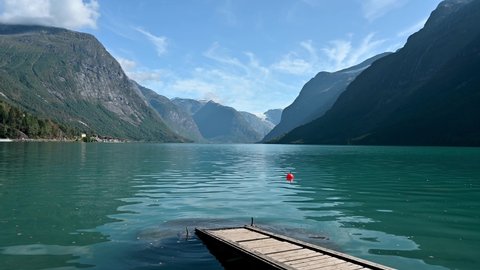 Beautiful Lake Lovatnet in Norway with a jetty crossing the turquoise water.