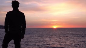 Sad young alone man looks thoughtfully at the ocean. Beautiful sunrise background. Travel and self-isolation, social distancing. Nature, sea, beach, morning - Powered by Shutterstock - Get 15% off with code: PIKWIZARD15