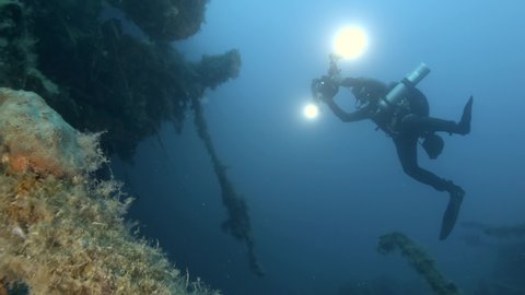 Scuba diver photographer shots truck on the shipwreck Swedish ferry MS Zenobia. Wreck diving. Mediterranean sea, Cyprus