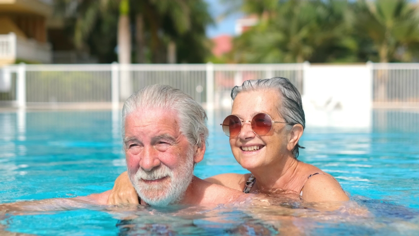 Couple of two happy seniors having fun and enjoying together in the swimming pool smiling and playing. Happy people enjoying summer outdoor in the water
 | Shutterstock HD Video #1078720115