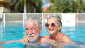 Couple of two happy seniors having fun and enjoying together in the swimming pool smiling and playing. Happy people enjoying summer outdoor in the water
 - Powered by Shutterstock - Get 15% off with code: PIKWIZARD15