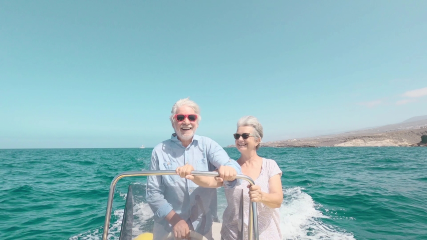 Beautiful and cute couple of seniors or old people in the middle of the sea driving and discovering new places with small boat. Mature woman holding a phone and taking a selfie with hew husband
 | Shutterstock HD Video #1078721543