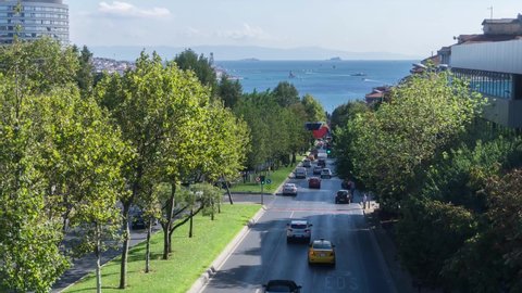 time lapse istanbul besiktas car traffic of the city on the tree-lined road and the sea traffic of the Bosphorus behind Maiden's Tower. turkey istanbul besiktas September 2, 2021