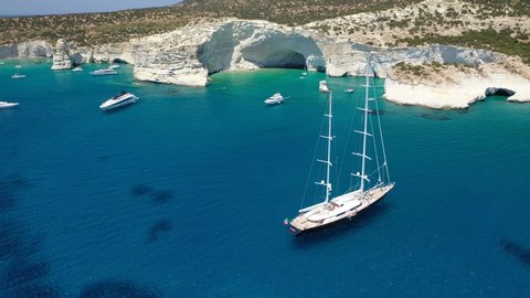 Arial drone video of Kleftiko a beautiful scenic white volcanic rock formation bay visited by sail boats and yachts with turquoise crystal clear sea and caves, Sea Meteora of Greece, Milos island