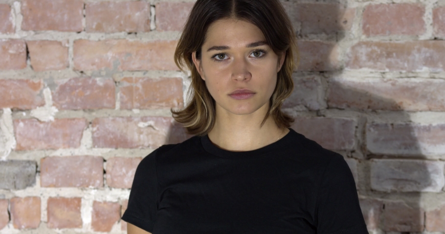 A closeup view of a woman with short hair and a black shirt frowning then smiling in 4k Royalty-Free Stock Footage #1078745768
