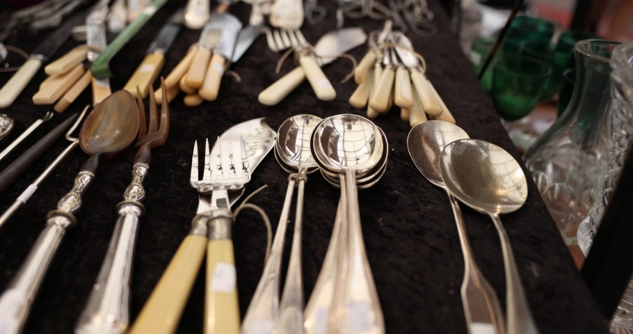 A  display of silver vintage cutlery on black velvet