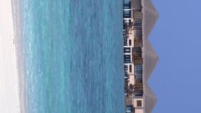 Tropical travel destination with ocean seascape and luxury water bungalows. Vertical format video