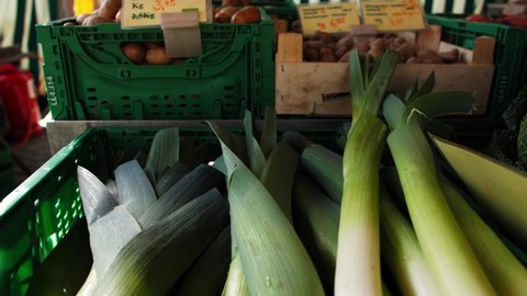 A closeup of the fresh green leeks in the plastic crate in the market in 4