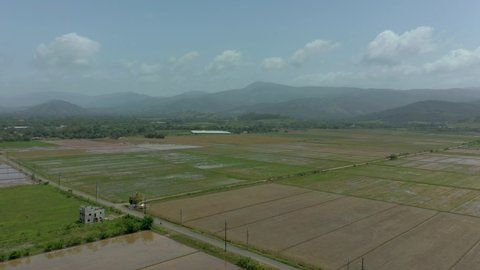 Aerial drone view of Waterlogged Fields in La Vega. Shot of green lush mountain landscape fruitful wet green field. Aerial view of farm landscape with multiple farms and green fields on a sunset.