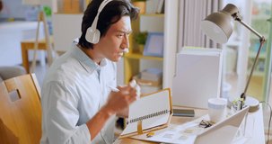 asian man has video meeting - he cannot hear clear from headset when using laptop at home