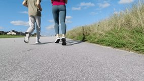Slow motion 4K video of happy young mother and her teen son jogging together at morning at sunny summer day