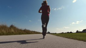 60fps 4K video of sporty woman in sport wear jogging in morning at summer time