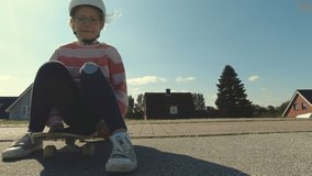 Slow motion 4K video of happy children skateboarding and having fun on longboard  at summer sunny day
