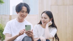Young asian couple watching a smart phone. Video distribution service.