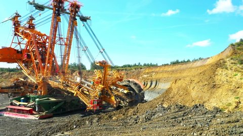 Bucket wheel excavator at work in coal mine. Mining industry from above. Open pit in Central Europe. Heavy industry before Green deal.